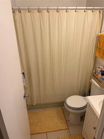 a bathroom with a toilet and a shower curtain