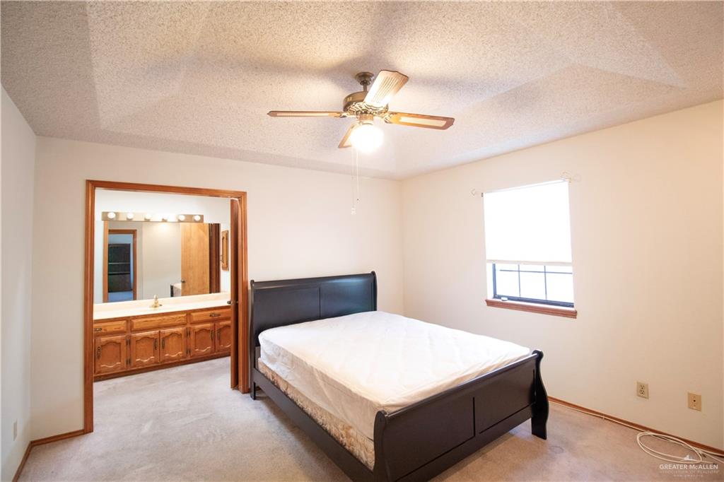 401 Taurus Street Mission, TX 78572 - Photo 13 of 18 a bedroom with a large bed and a chandelier