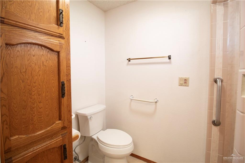 401 Taurus Street Mission, TX 78572 - Photo 15 of 18 a white toilet sitting next to a shower curtain