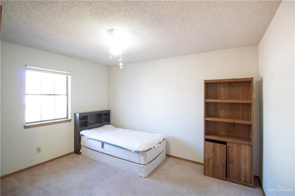 401 Taurus Street Mission, TX 78572 - Photo 16 of 18 a spacious bedroom with a bed and a window