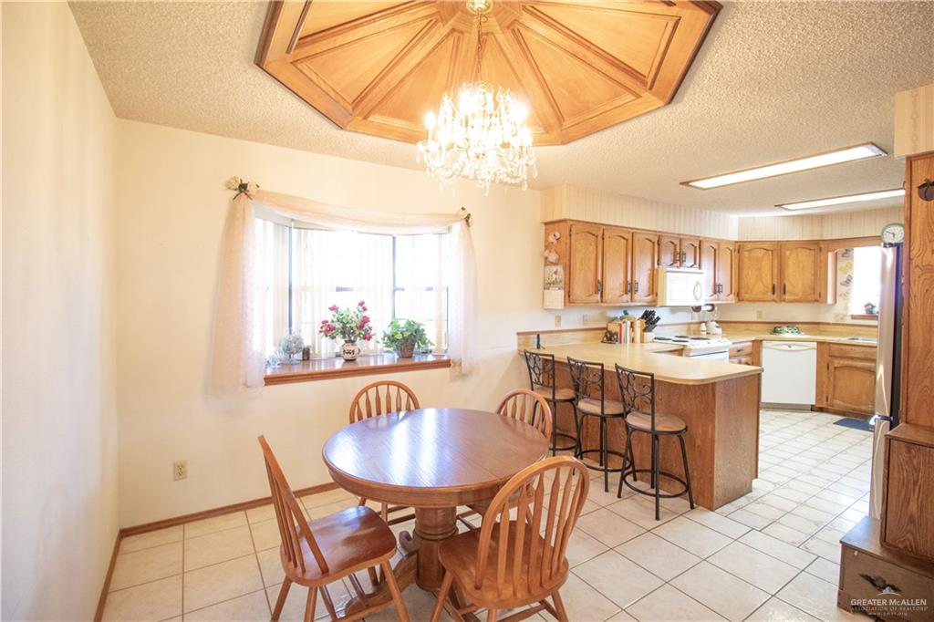 401 Taurus Street Mission, TX 78572 - Photo 6 of 18 a view of a dining room with furniture a chandelier and kitchen view