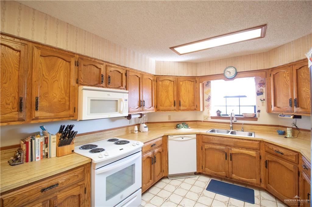 401 Taurus Street Mission, TX 78572 - Photo 7 of 18 a kitchen with a sink stove top oven and cabinets