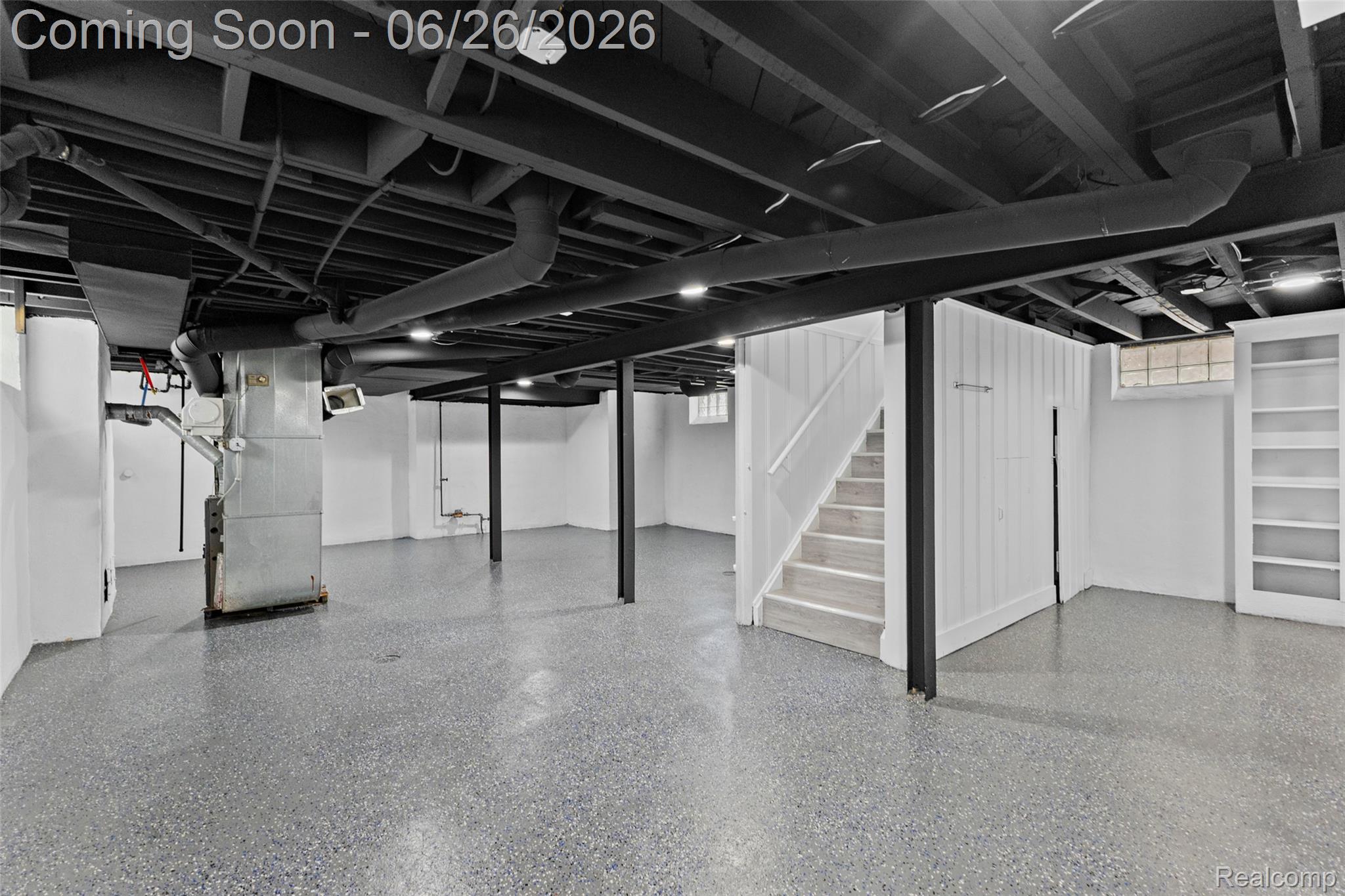 8310 Whitcomb Detroit, MI 48228 - Photo 25 of 26 Spacious lower level featuring exposed black painted ceiling joists, durable speckled flooring, white paneled walls, recessed lighting, and built-in shelving