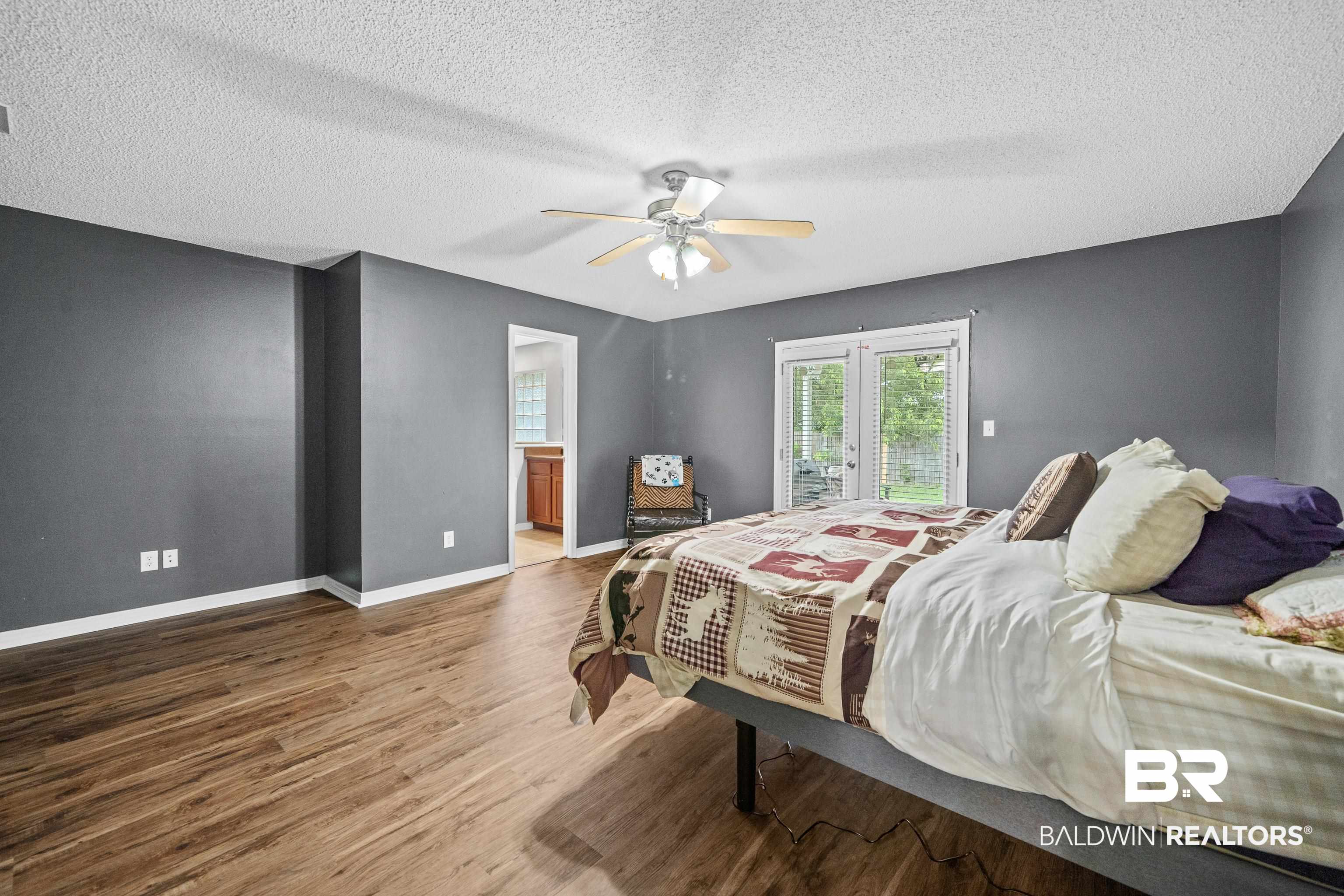 9552 Collier Loop Daphne, AL 36526 - Photo 16 of 28 Bedroom with wood finished floors, a textured ceiling, baseboards, french doors, and access to outside
