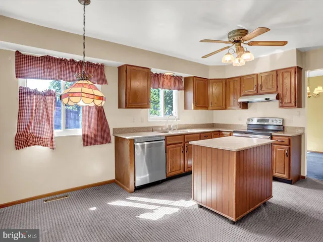 a kitchen with stainless steel appliances granite countertop a sink a stove and a refrigerator