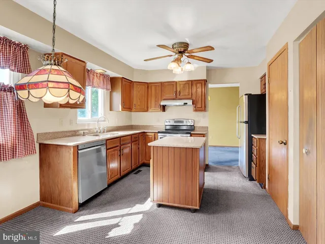 a kitchen with stainless steel appliances granite countertop a refrigerator a stove a sink and a microwave