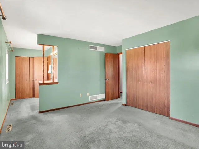 a view of an empty room with window and stairs