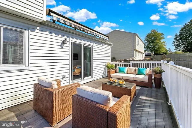 a view of a patio with couches chairs and wooden floor