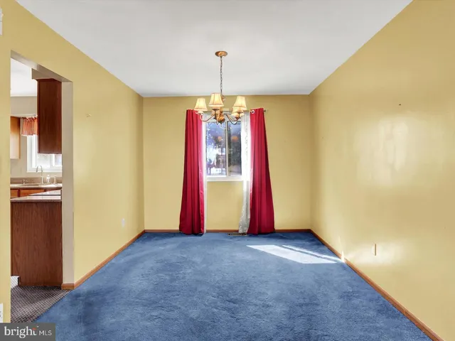 a view of a room with gym equipment and a chandelier