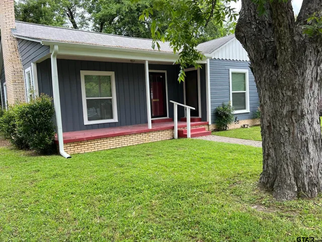 a view of a house with a backyard and porch