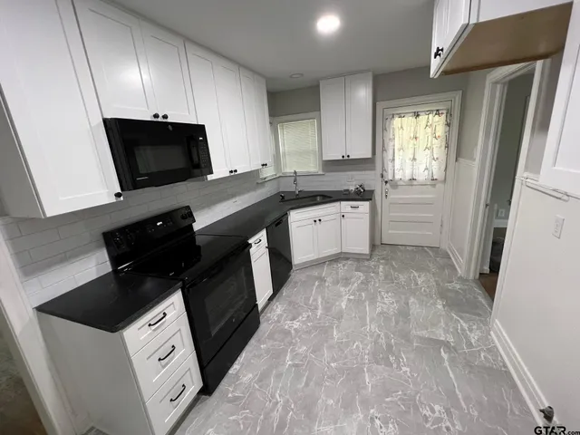 a kitchen with a sink stove and microwave