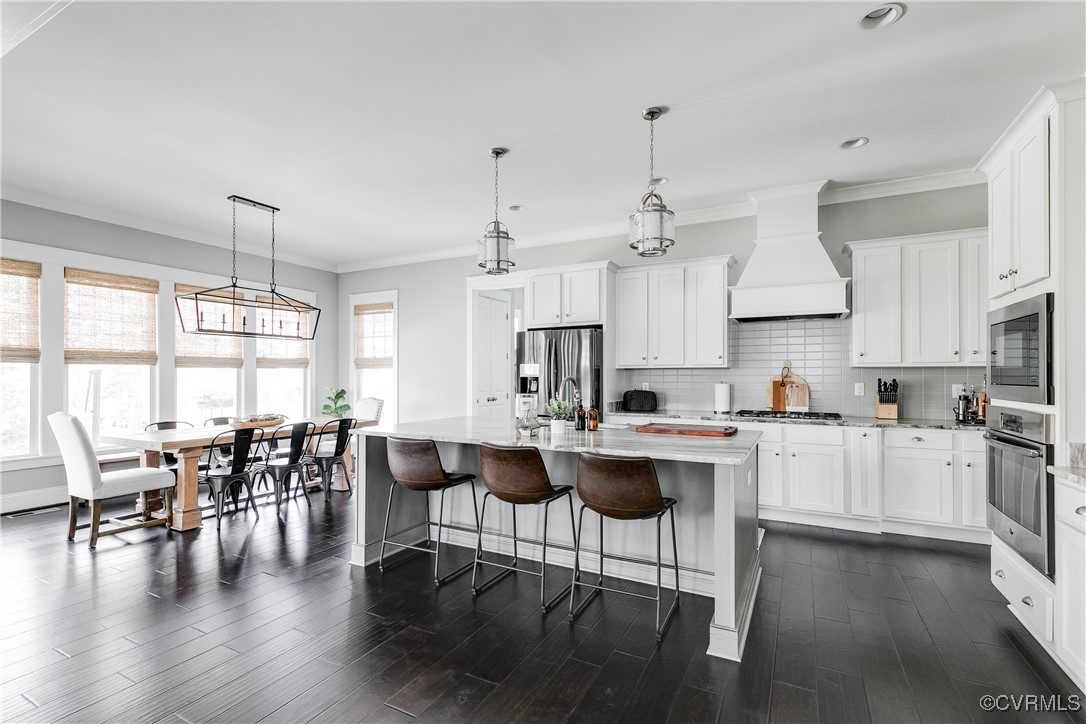 16506 Binley Road Midlothian, VA 23112 - Photo 19 of 49 a kitchen with stainless steel appliances granite countertop a stove a refrigerator a kitchen island a dining table and chairs with wooden floor