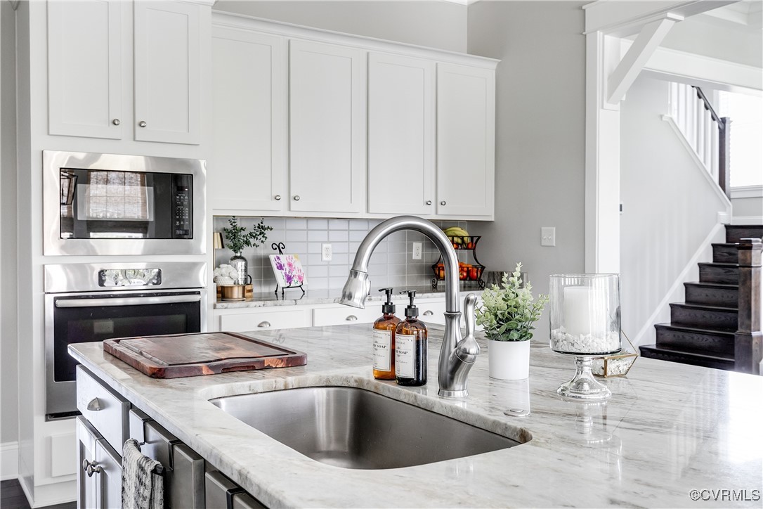 16506 Binley Road Midlothian, VA 23112 - Photo 22 of 49 a kitchen with a sink dishwasher a stove and a microwave with wooden floor