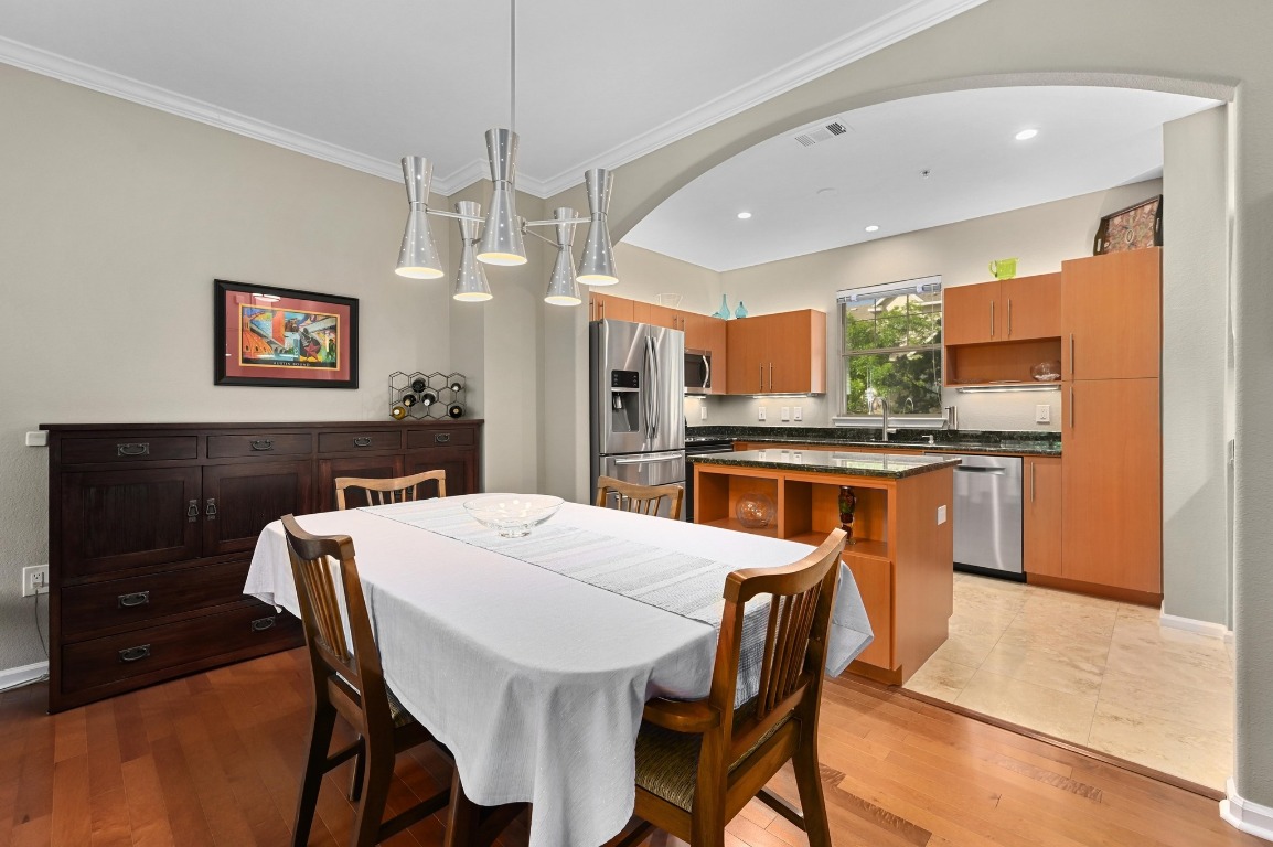 11203 Ranch Road 2222, Unit 1104 Austin, TX 78730 - Photo 11 of 24 a kitchen with stainless steel appliances kitchen island granite countertop a dining table and chairs