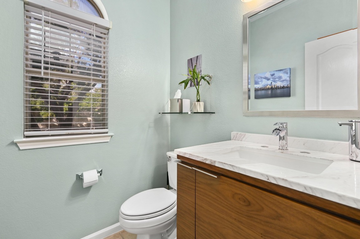 11203 Ranch Road 2222, Unit 1104 Austin, TX 78730 - Photo 16 of 24 a bathroom with a sink a toilet and a mirror