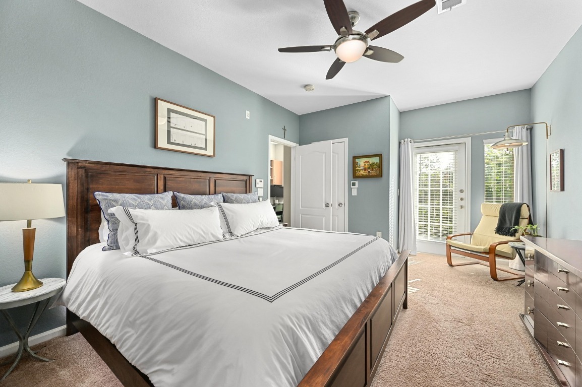 11203 Ranch Road 2222, Unit 1104 Austin, TX 78730 - Photo 21 of 24 a bedroom with a large bed couch and two windows