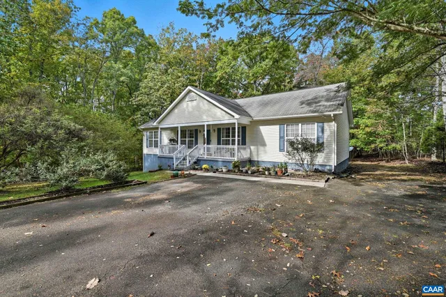 a view of a house with a yard and large tree