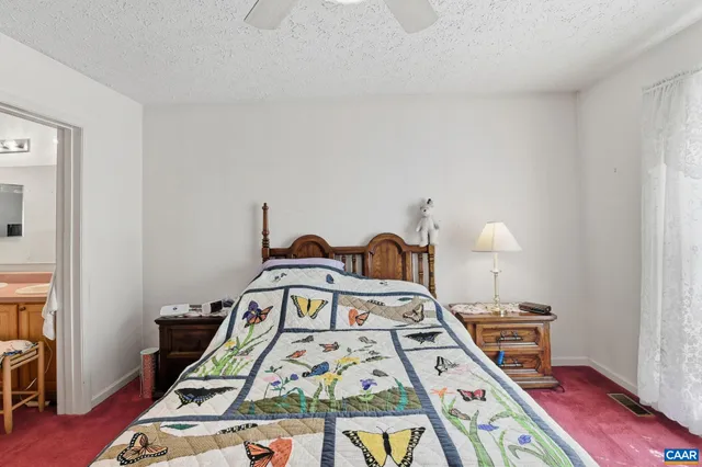 a bed sitting in a bedroom next to a window with pc on the table