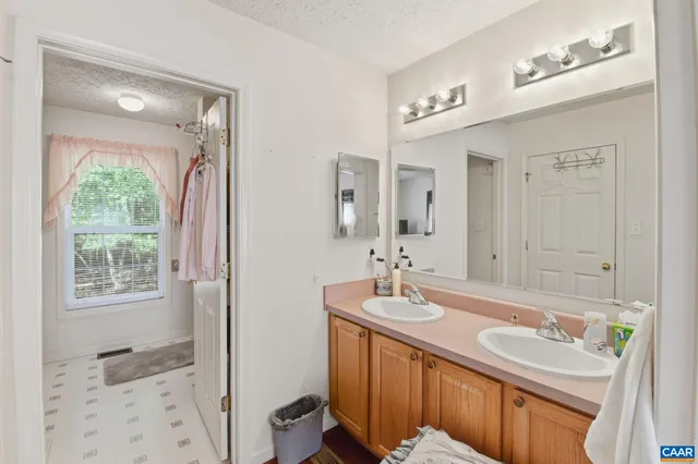 a bathroom with a sink double vanity granite tub and a mirror