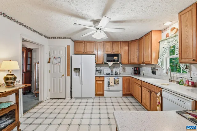 a kitchen with stainless steel appliances granite countertop a refrigerator a sink dishwasher a stove with wooden cabinets and floor