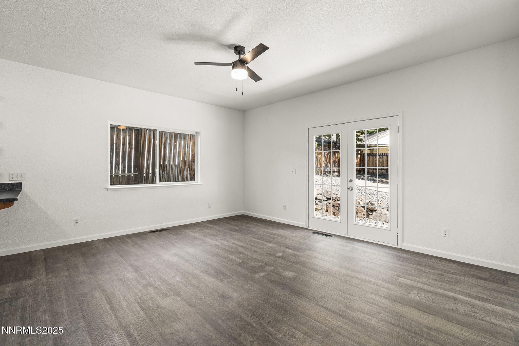 515 College Drive Reno, NV 89503 - Photo 4 of 25 an empty room with wooden floor chandelier and windows