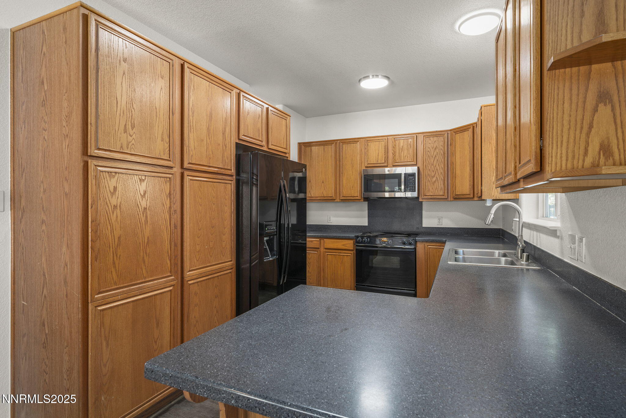 515 College Drive Reno, NV 89503 - Photo 9 of 25 a kitchen with granite countertop stainless steel appliances a refrigerator stove top oven and sink