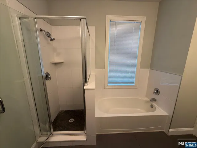 a bathroom with a tub shower vanity and a sink