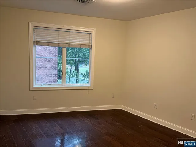a view of a small space with wooden floor and a window