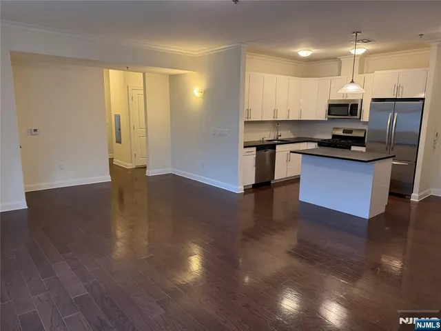 a kitchen with stainless steel appliances granite countertop a refrigerator a sink dishwasher and a stove with wooden floor