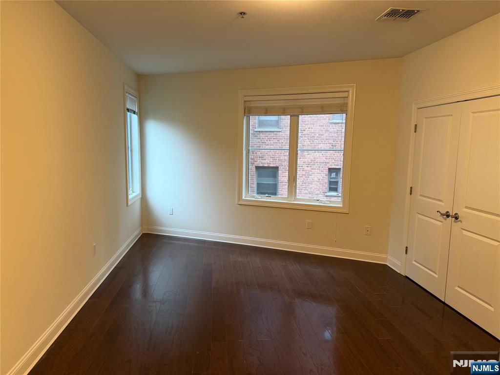2001 Hudson Terrace, Unit 404 Fort Lee, NJ 07024 - Photo 6 of 21 a view of an empty room with wooden floor and a window