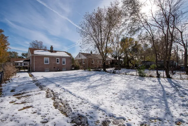a front view of a house with a yard and trees