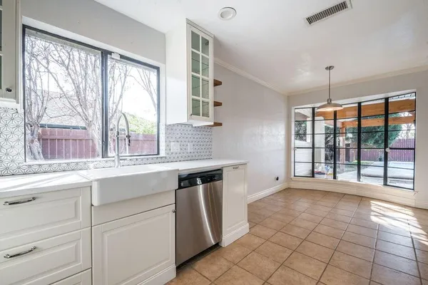 a kitchen with a sink window and cabinets