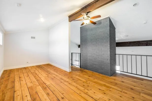 a view of a big room with wooden floor and a cabinet