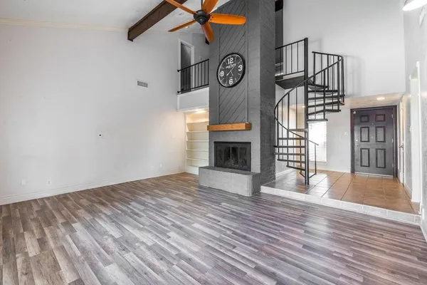 a view of empty room with wooden floor and window