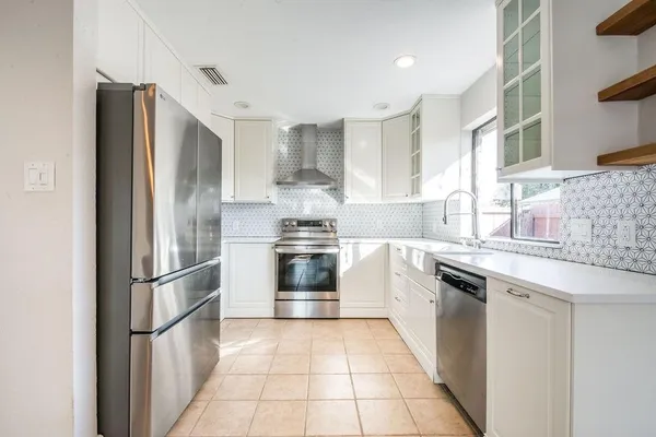 a kitchen with stainless steel appliances granite countertop a refrigerator and a sink