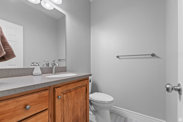 1501 West Elk Circle Mapleton, UT 84664 - Photo 30 of 39 Bathroom featuring a wood-finish vanity with a light-toned countertop, an undermount sink, and a chrome faucet