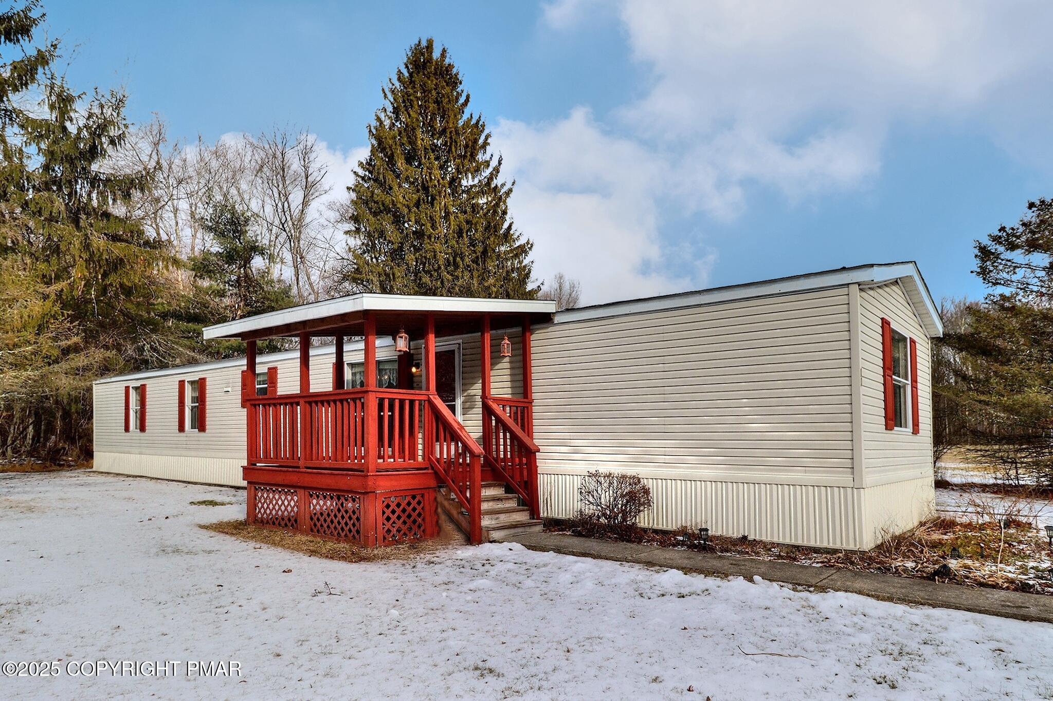 a view of a small house with wooden fence