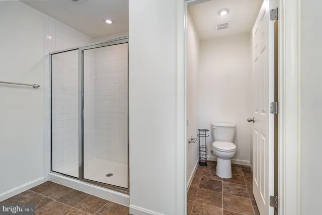 a bathroom with a toilet and a shower
