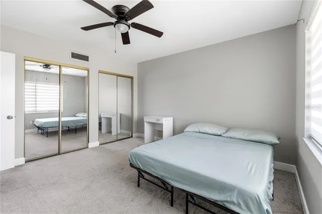 a view of a white house with a yard and large tree