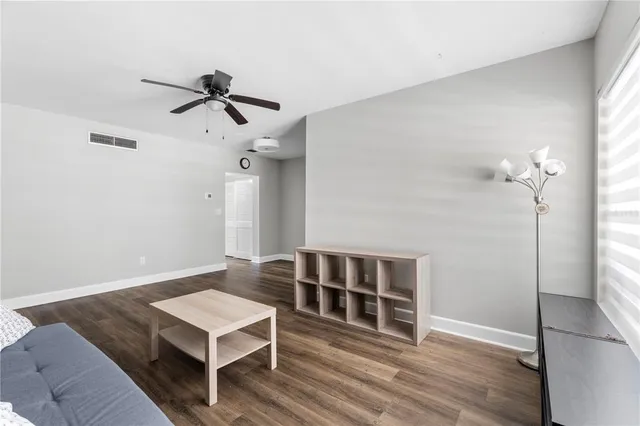 a view of a livingroom with wooden floor and staircase