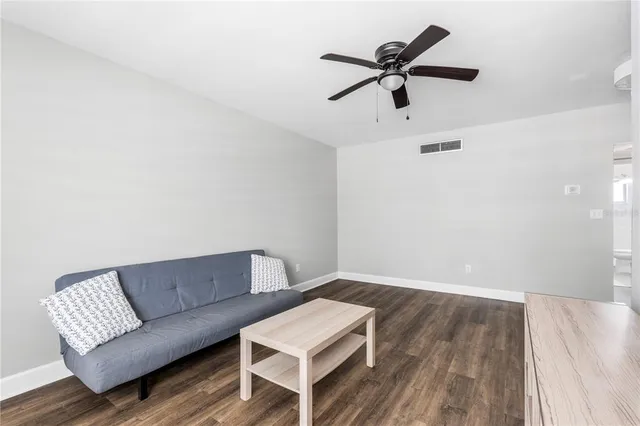 a living room with a bed furniture and a wooden floor
