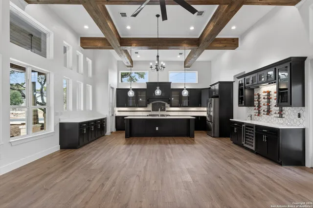 a large kitchen with stainless steel appliances double vanity and a wooden floors