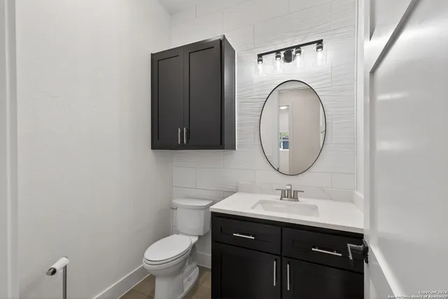 a bathroom with a toilet sink and mirror
