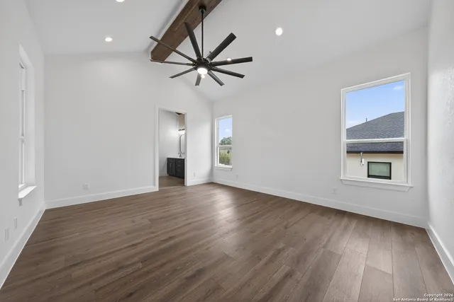 a view of empty room with wooden floor and window