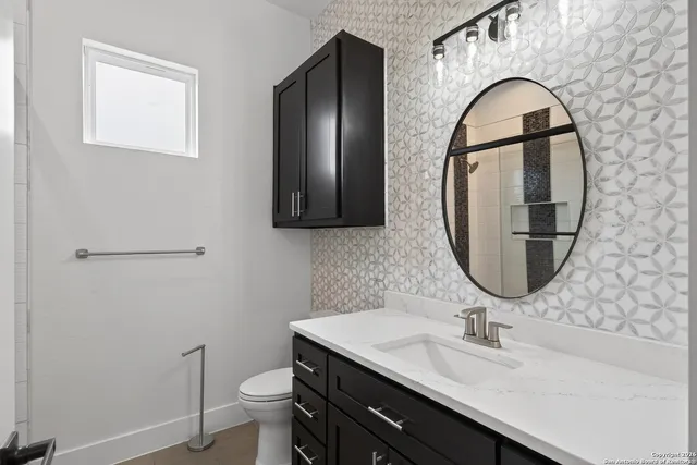 a bathroom with a toilet sink and mirror