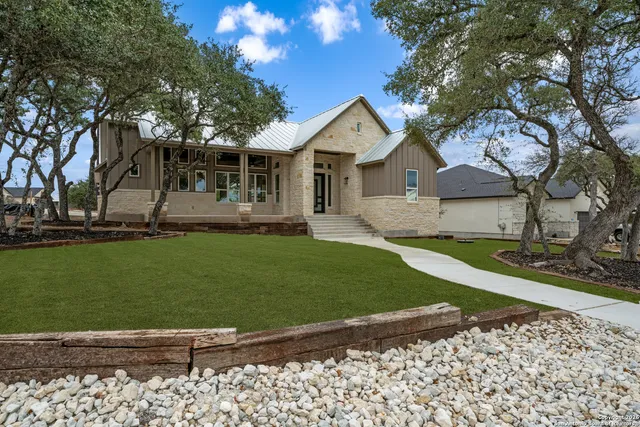 a front view of a house with a garden and yard