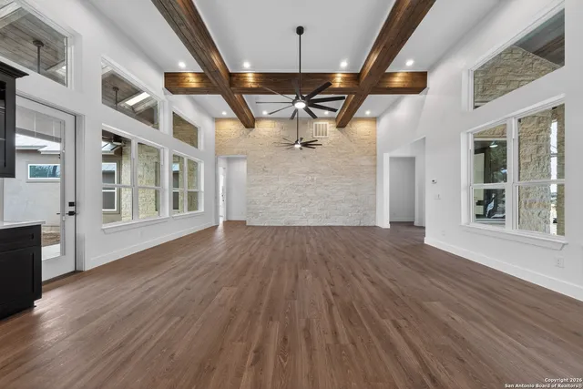 a view of a room with wooden floors and windows