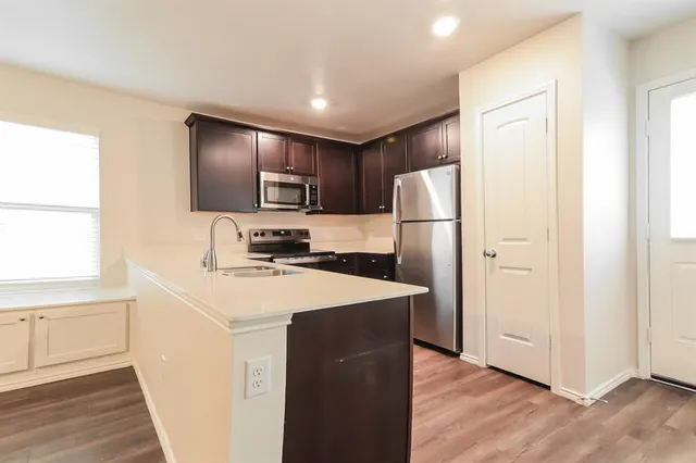 a kitchen with refrigerator cabinets and wooden floor