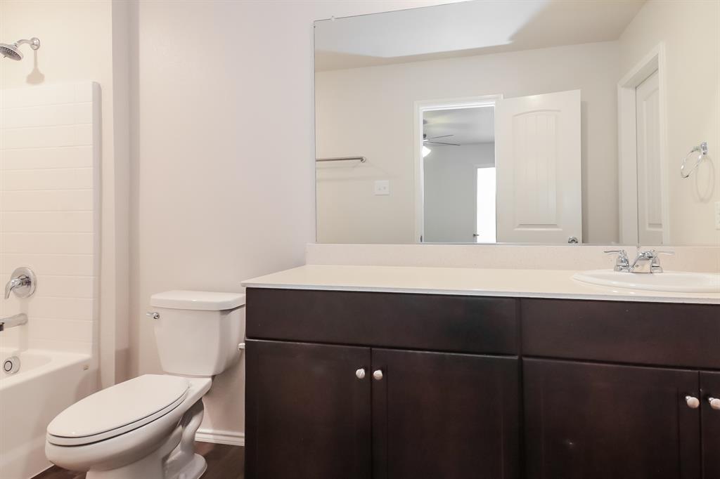 5213 Longshadow Drive Princeton, TX 75407 - Photo 10 of 16 a bathroom with a sink vanity mirror and toilet