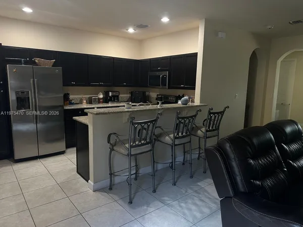 a kitchen with stainless steel appliances a sink a table and chairs